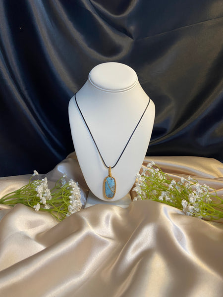 light blue, dark blue, white and grey rectangle larimar pendant with looped wire detailing.