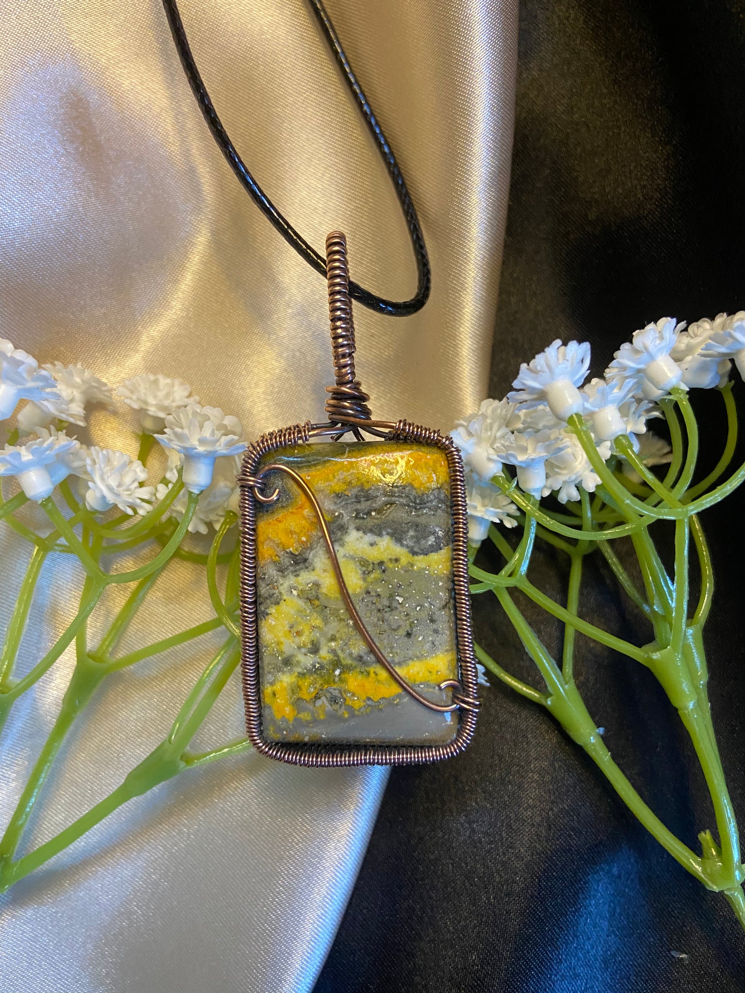 rectangle yellow, orange and grey bumblebee jasper pendant wrapped in oxidized copper wire with curled wire detailing. Comes on a 20" black adjustable cord. Made with love.